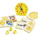 Educational clock set with cards and dice on a white background