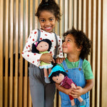 HABA Cari 12" Black Baby Doll with Black Pigtails, Embroidered Face, Removable Green Dress, Machine Washable Soft Baby Doll - 18 Months+