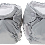 Two gray cloth diapers with button closures on a white background
